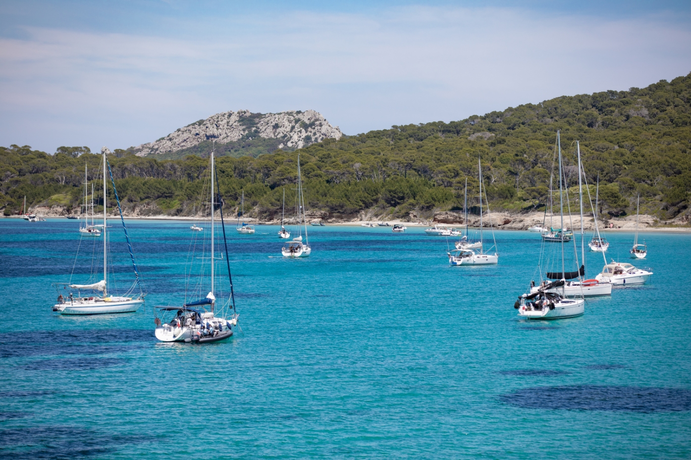 dove alloggiare a porquerolles? Barche ormeggiate su una delle spiagge di Porquerolles con acque turchesi.