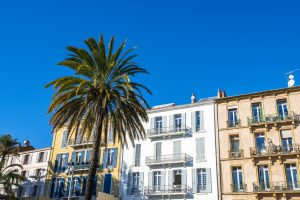 Palmiers et immeubles colorés de la ville de Hyères - hotel les medes porquerolles